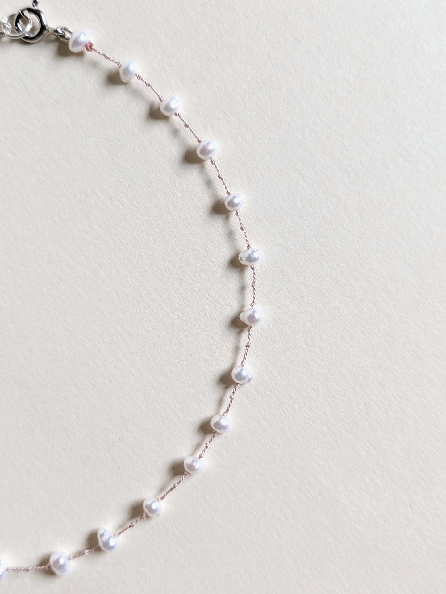 Pearl necklace on a light gray background