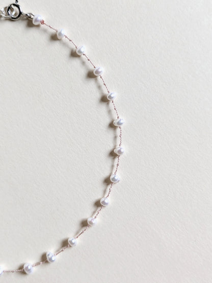 Pearl necklace on a light gray background