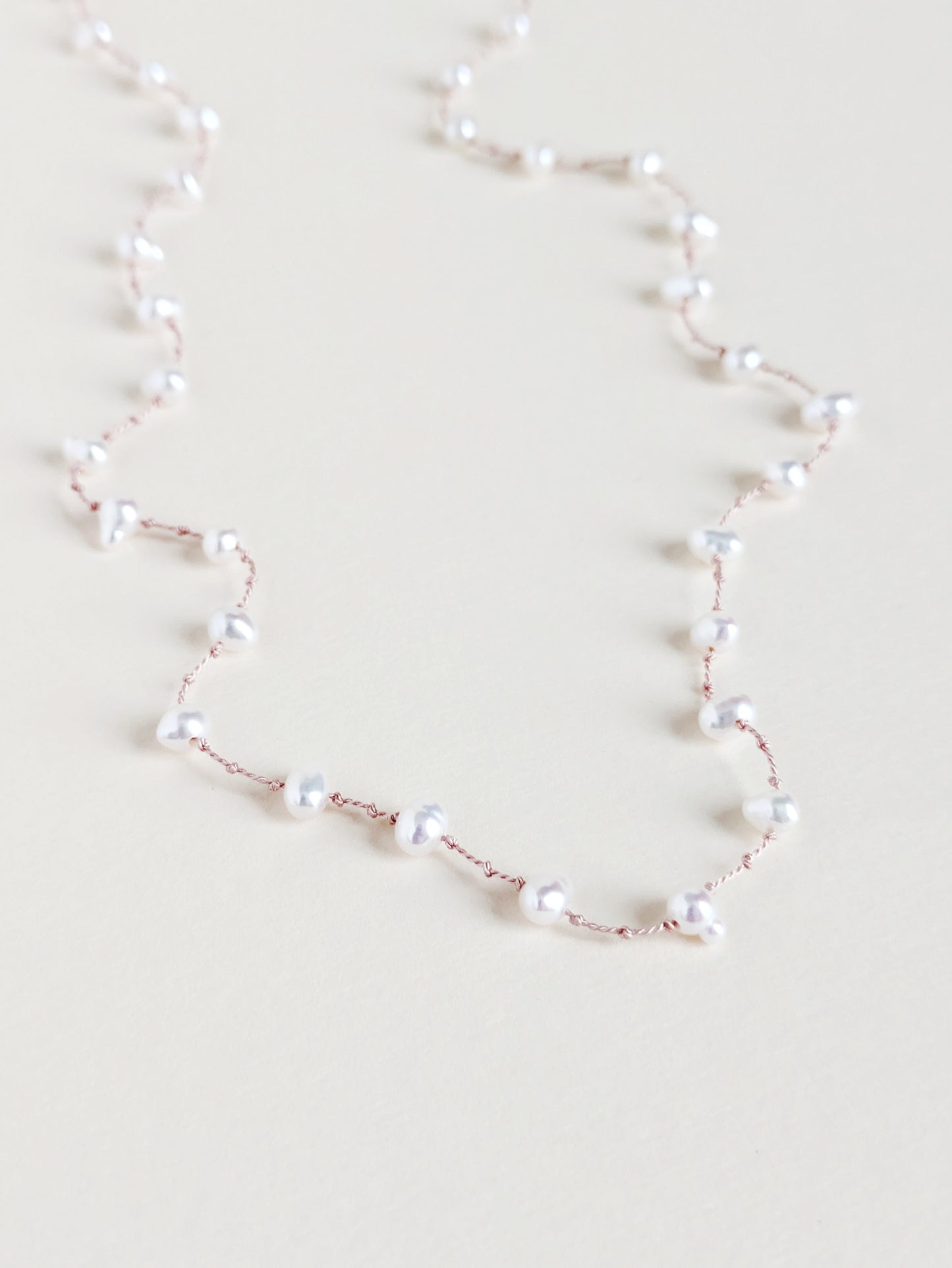 Pearl necklace on a light beige background