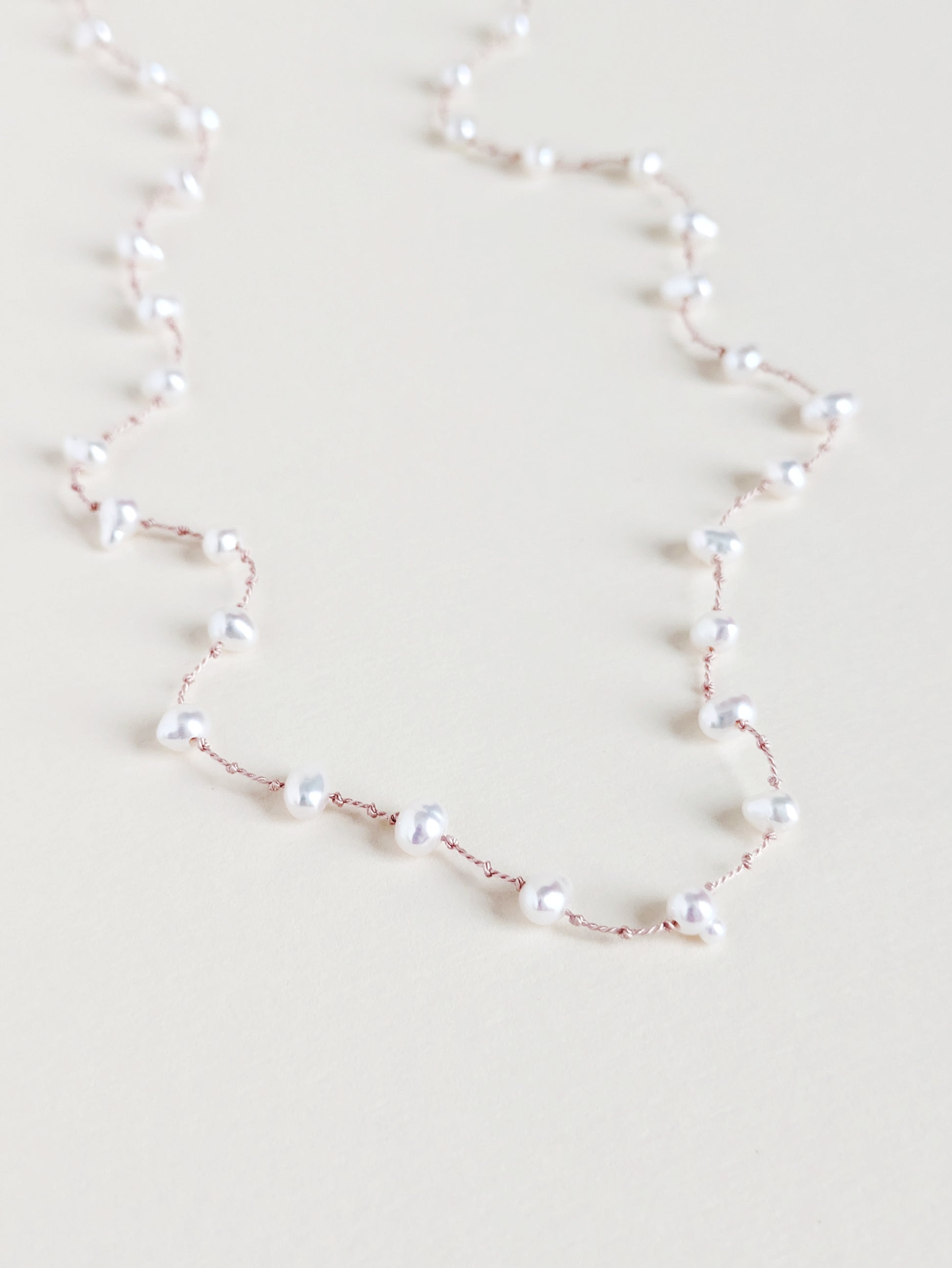 Pearl necklace on a light beige background