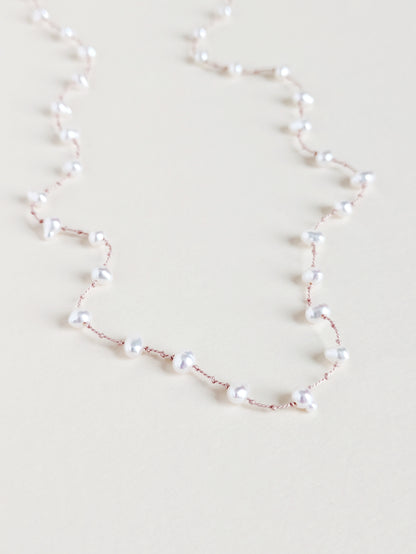 Pearl necklace on a light beige background