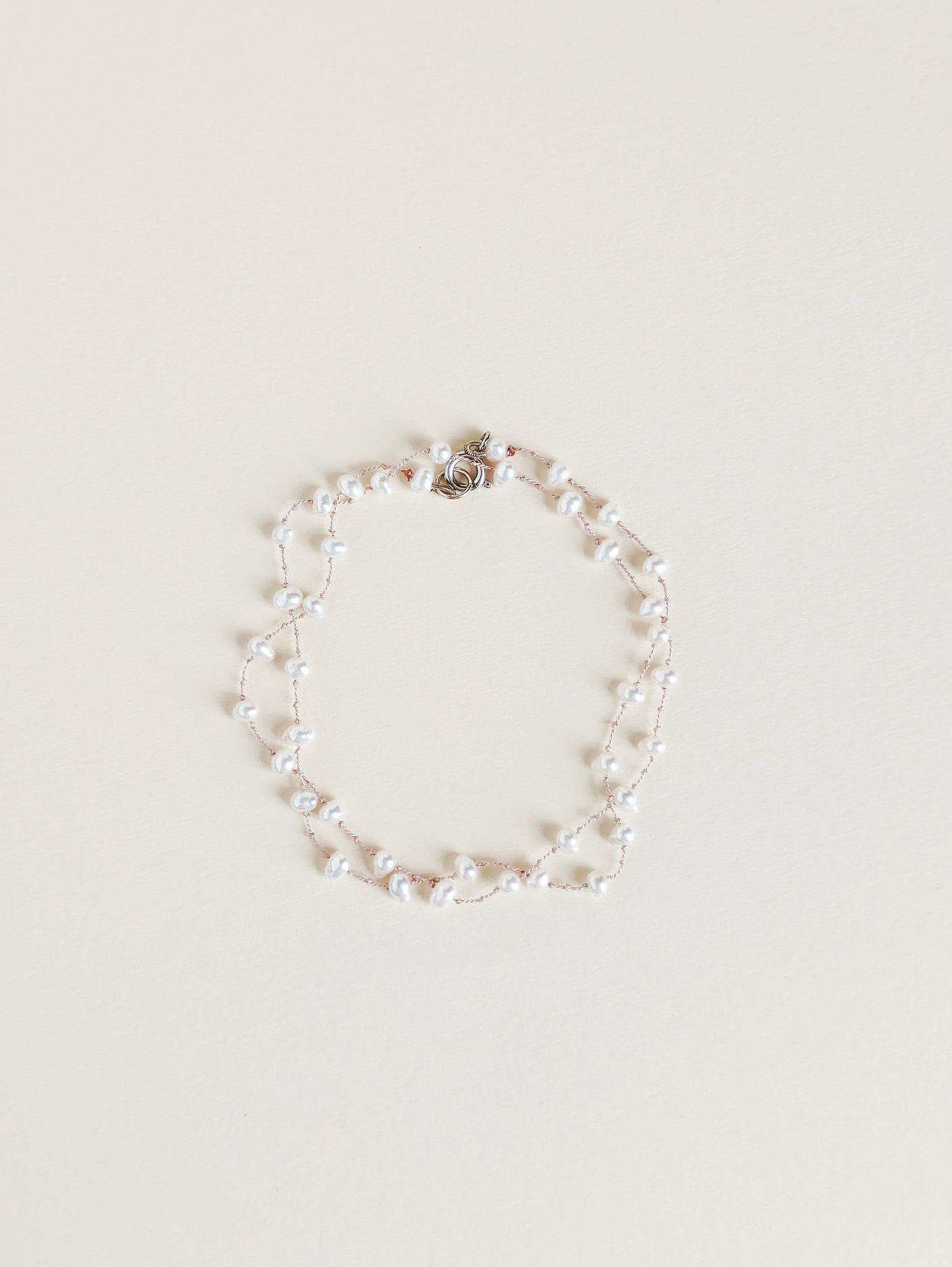 Pearl bracelet on a light beige background