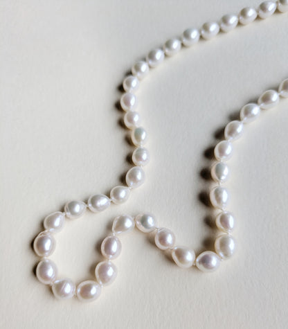 Pearl necklace on a light gray background