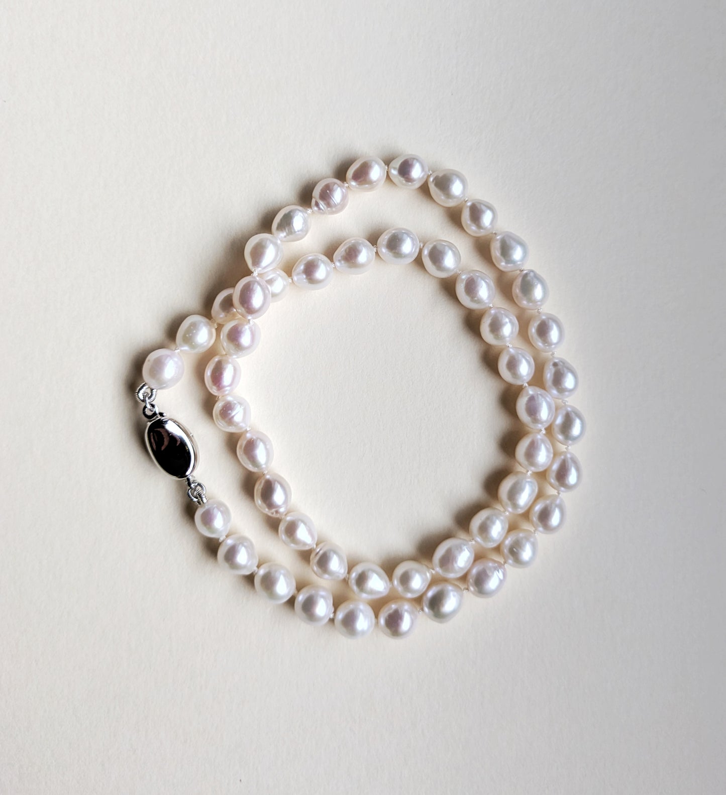 Pearl necklace on a light gray background