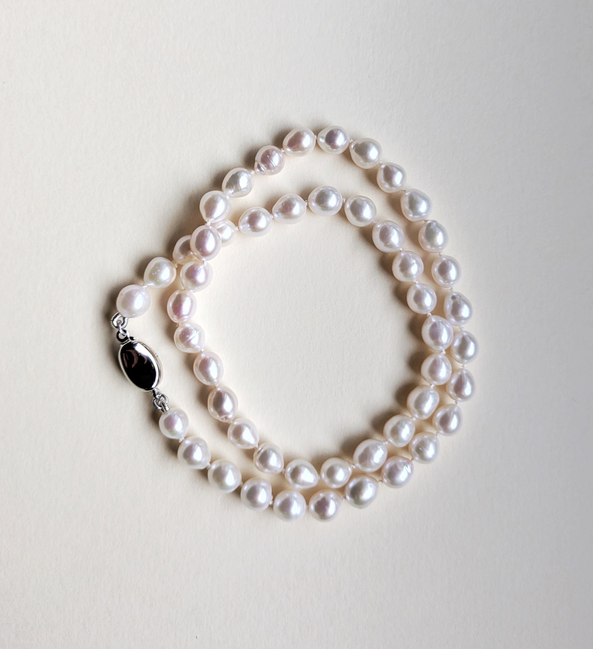 Pearl necklace on a light gray background