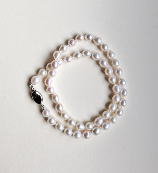 Pearl necklace on a light gray background