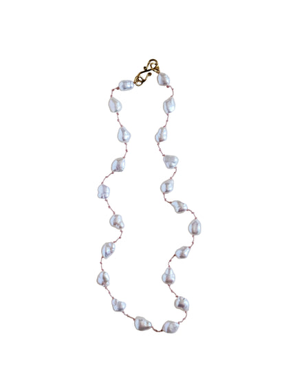 Pearl necklace with gold clasp on a white background