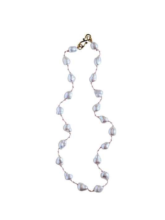 Pearl necklace with gold clasp on a white background