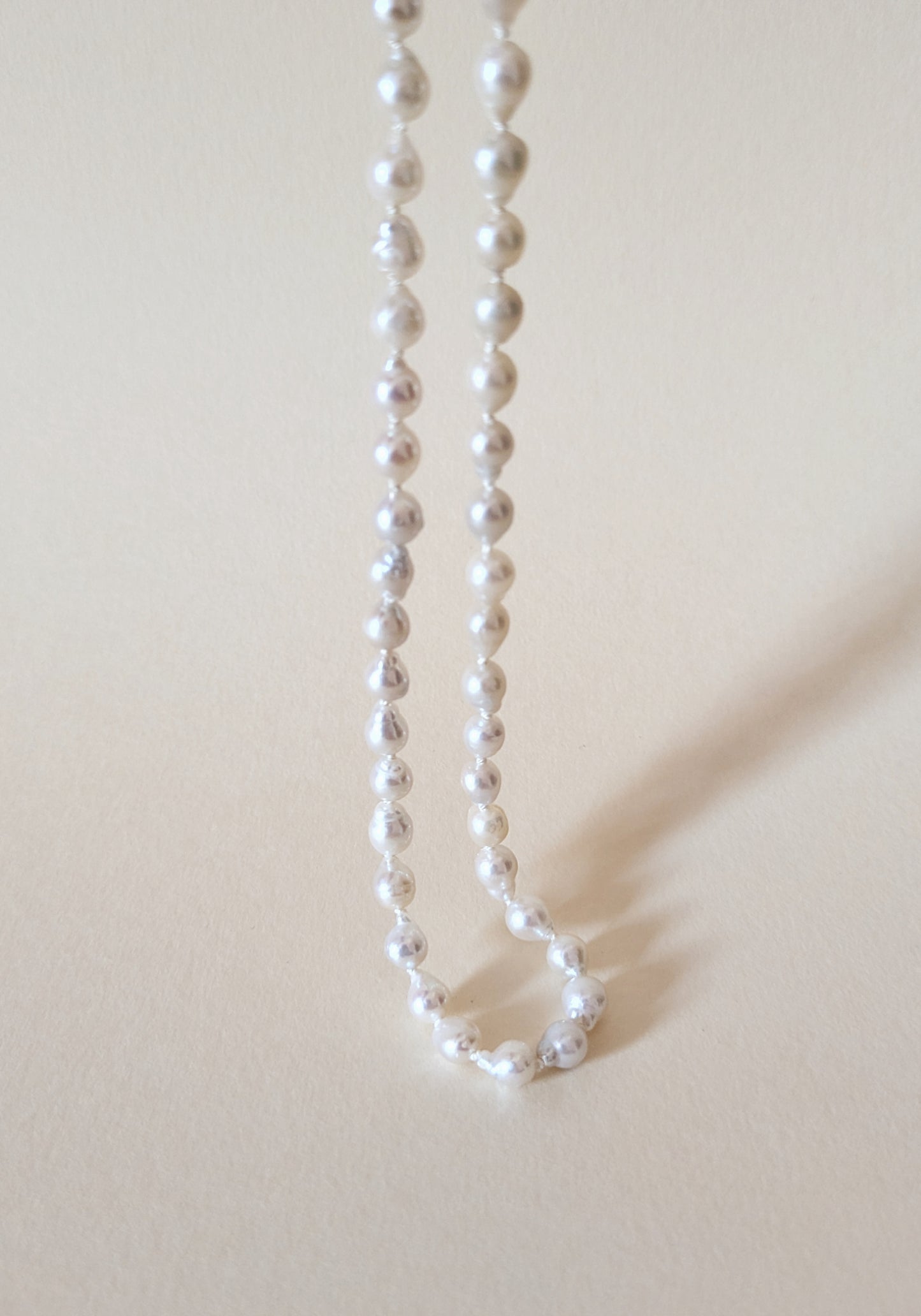 Pearl necklace on a beige background