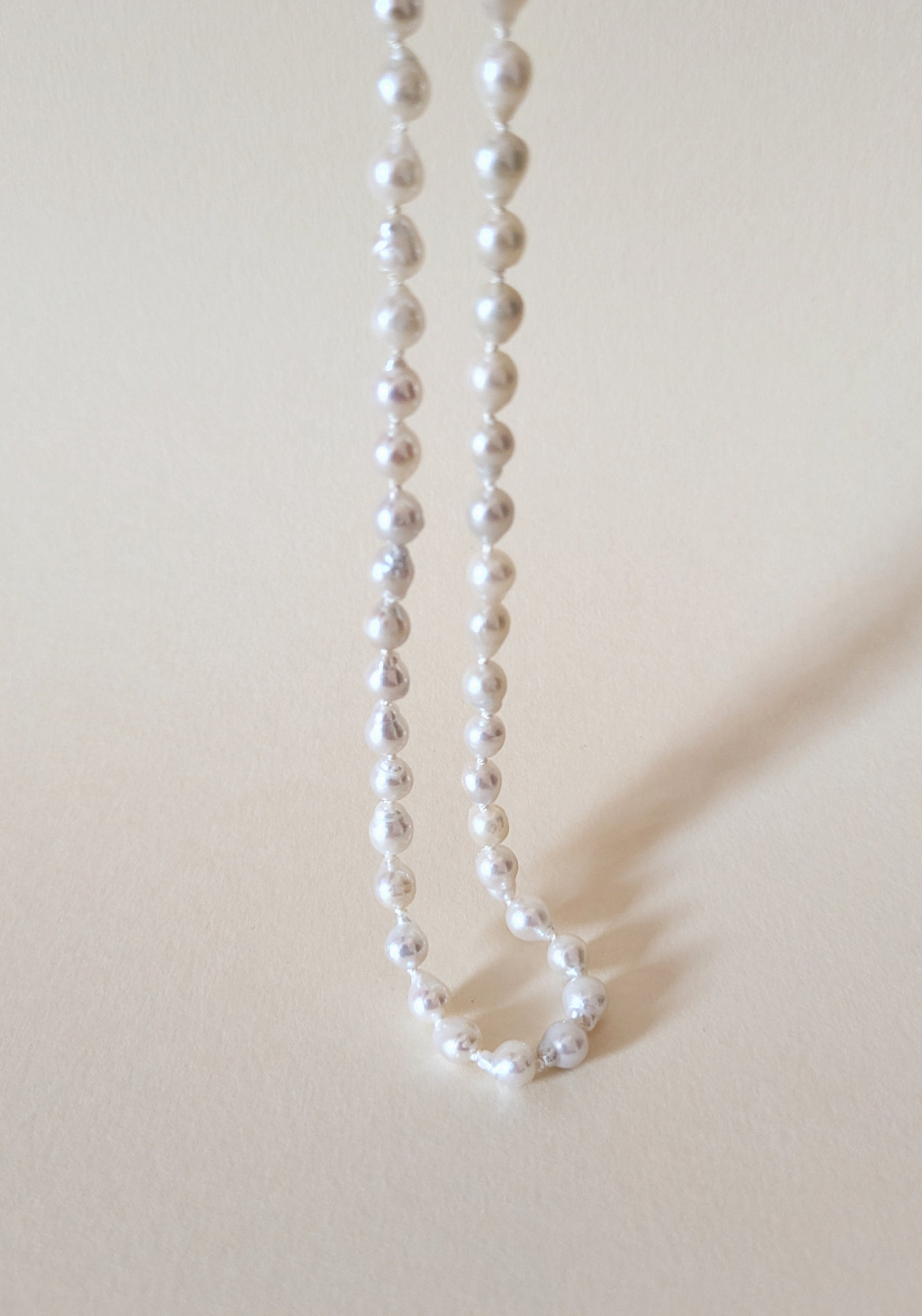 Pearl necklace on a beige background