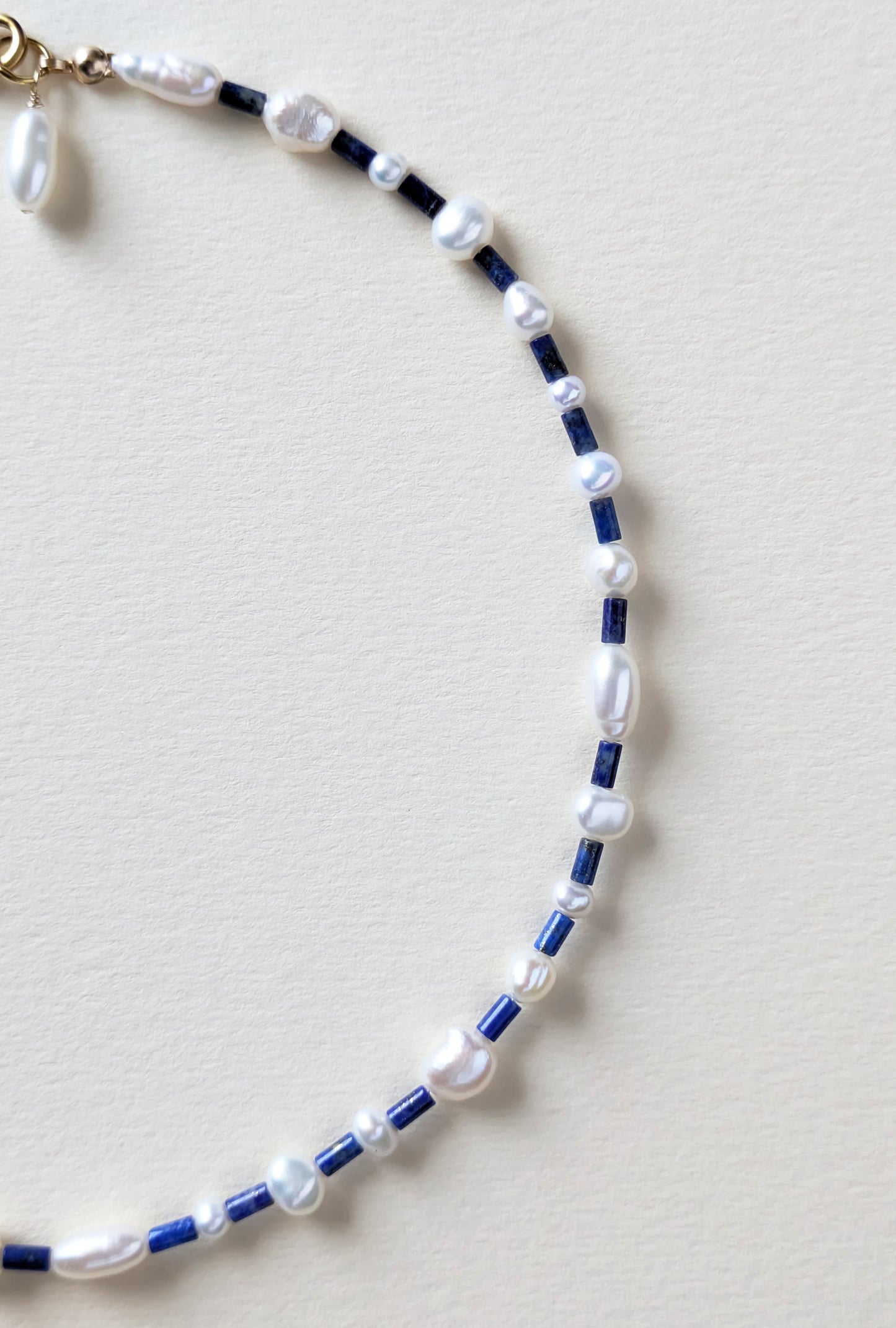 Necklace with lapis blue and pearls on a beige background