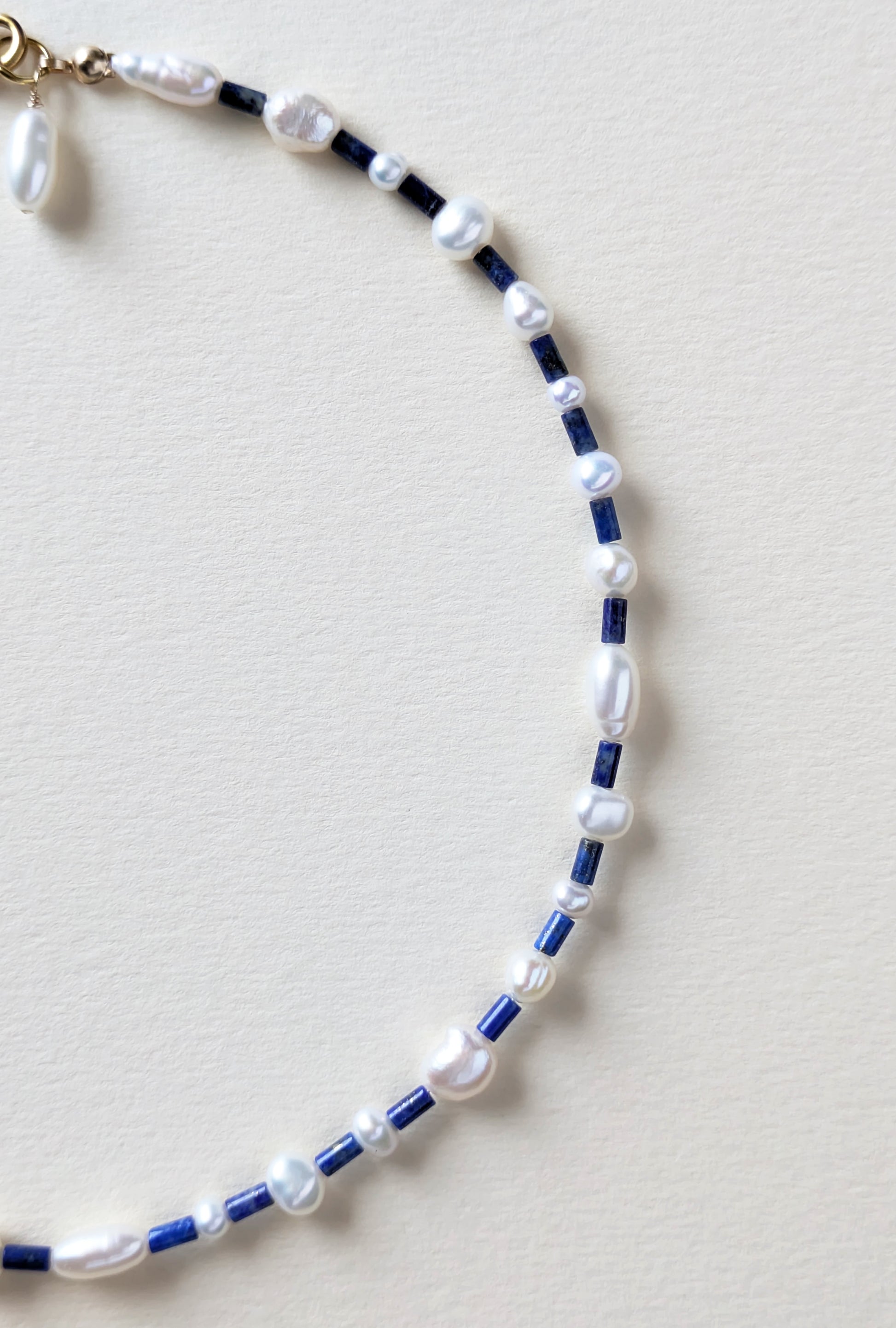 Necklace with lapis blue and pearls on a beige background