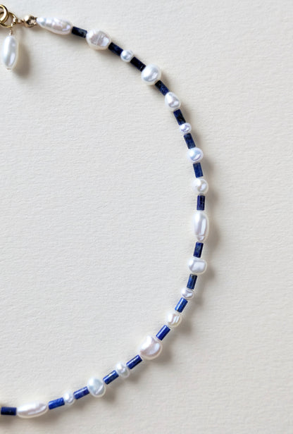 Necklace with lapis blue and pearls on a beige background