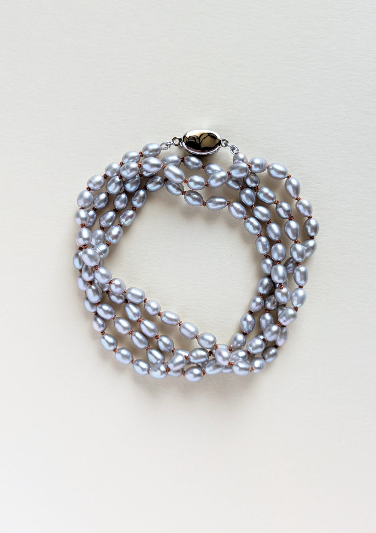 Silver pearl necklace or bracelet on a light background