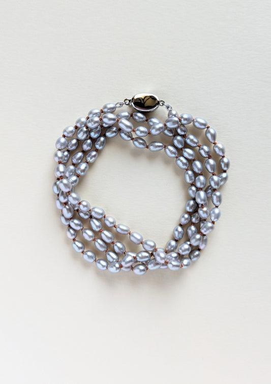 Silver pearl necklace or bracelet on a light background