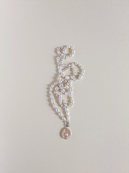 Pearl necklace with a pendant on a light gray background