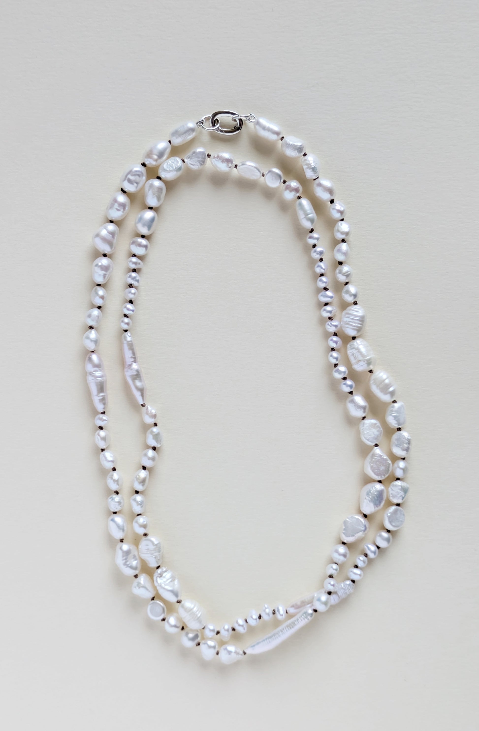 Pearl necklace on a light beige background