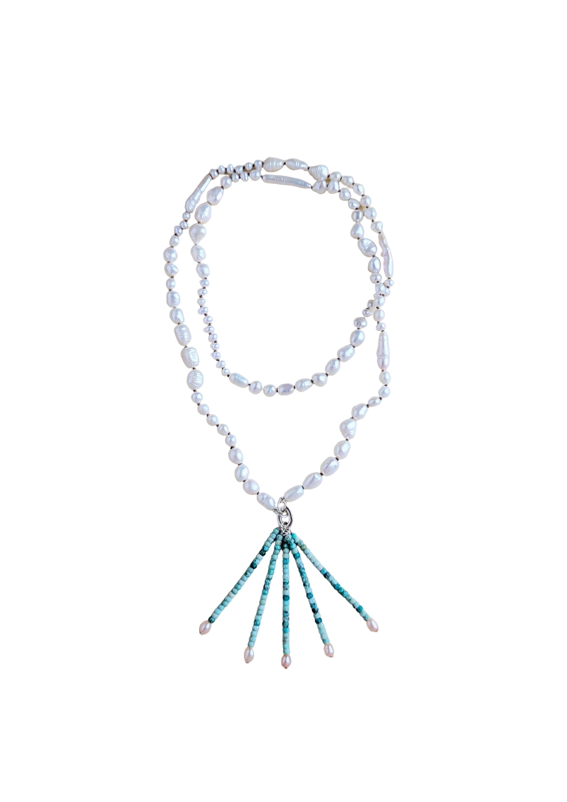 A double-strand necklace featuring irregular white freshwater pearls and a silver-tone clasp, with a drop pendant composed of turquoise and white beads ending in small pearl tips, displayed on a neutral beige background.