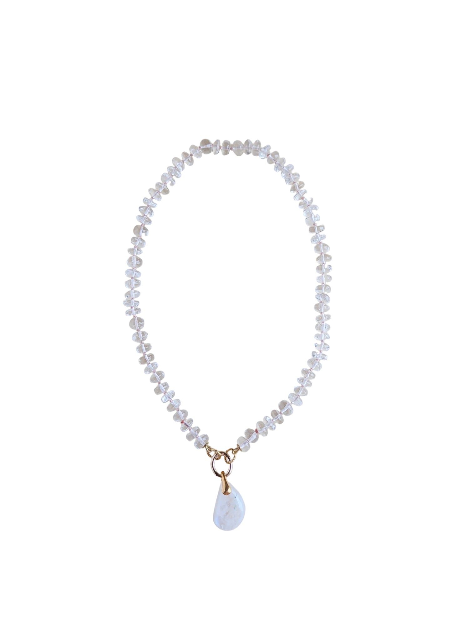 A delicate beaded necklace with clear faceted beads and a small white teardrop moonstone pendant with gold-tone metal accents, displayed on a plain light beige background.