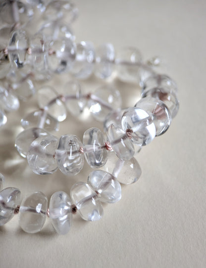 Close-up of clear quartz beads on a light background