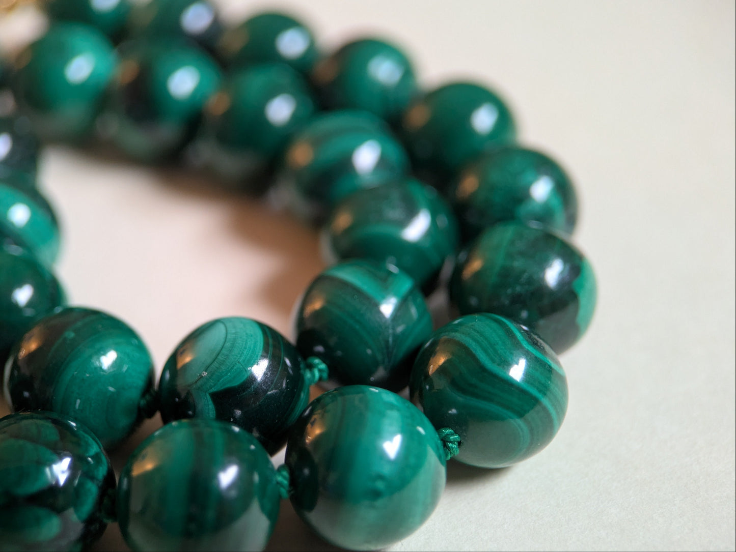 Close-up of a green malachite beaded bracelet on a light background