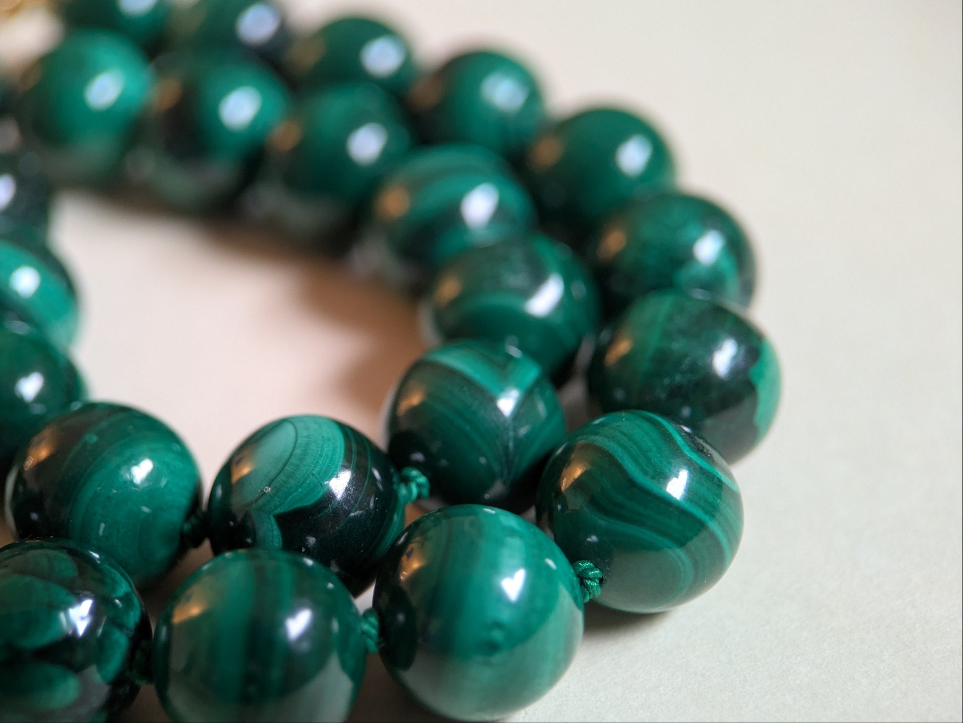 Close-up of a green malachite beaded bracelet on a light background