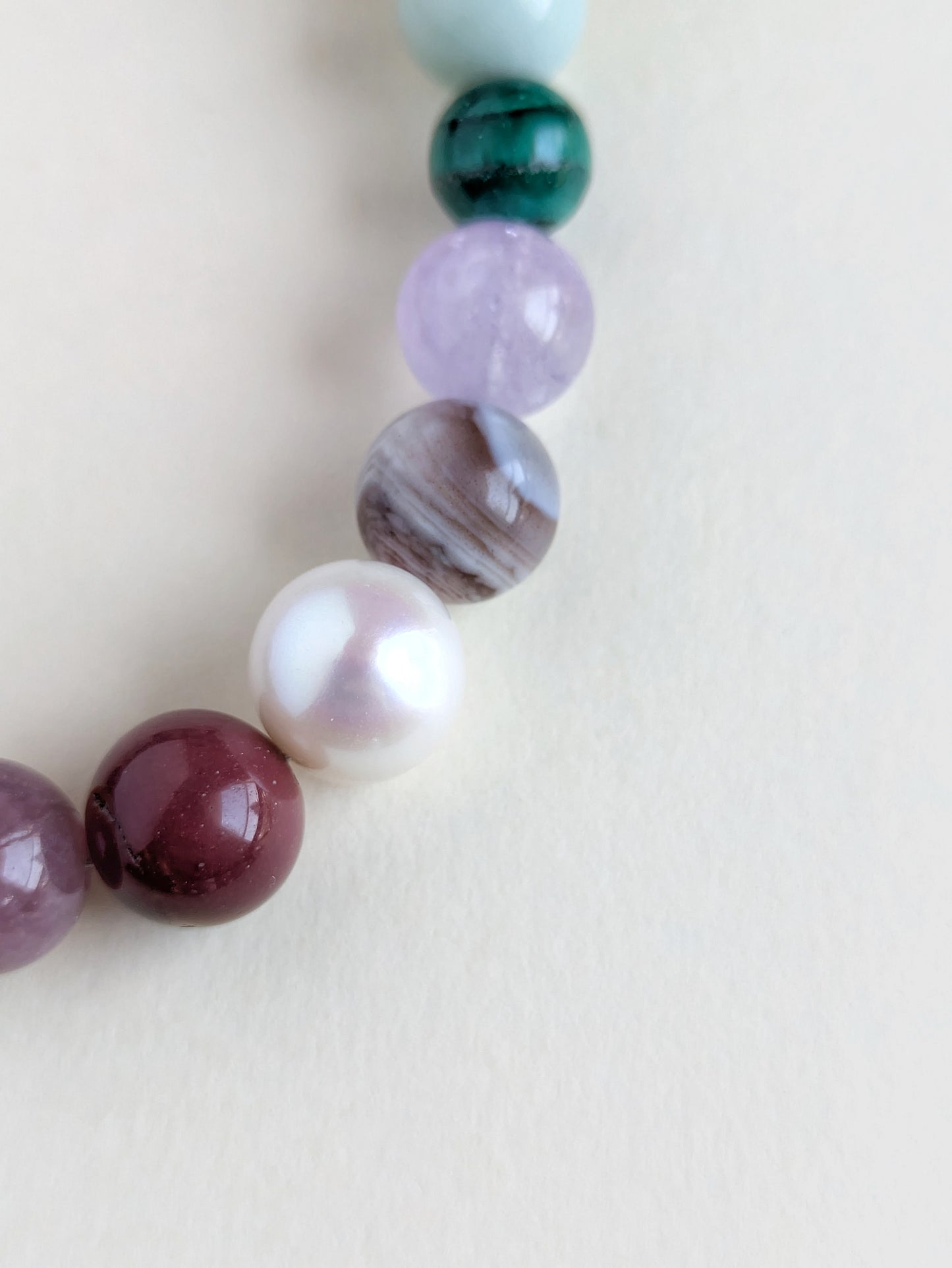 Close-up of the colorful gemstone beads on a beige background.