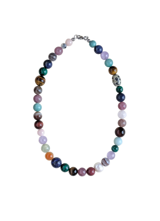 A multicolor beaded necklace made of polished gemstone-like beads in various colors, arranged in an oval shape on a plain white background.