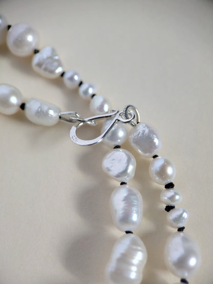 Clasp detail on a pearl necklace.