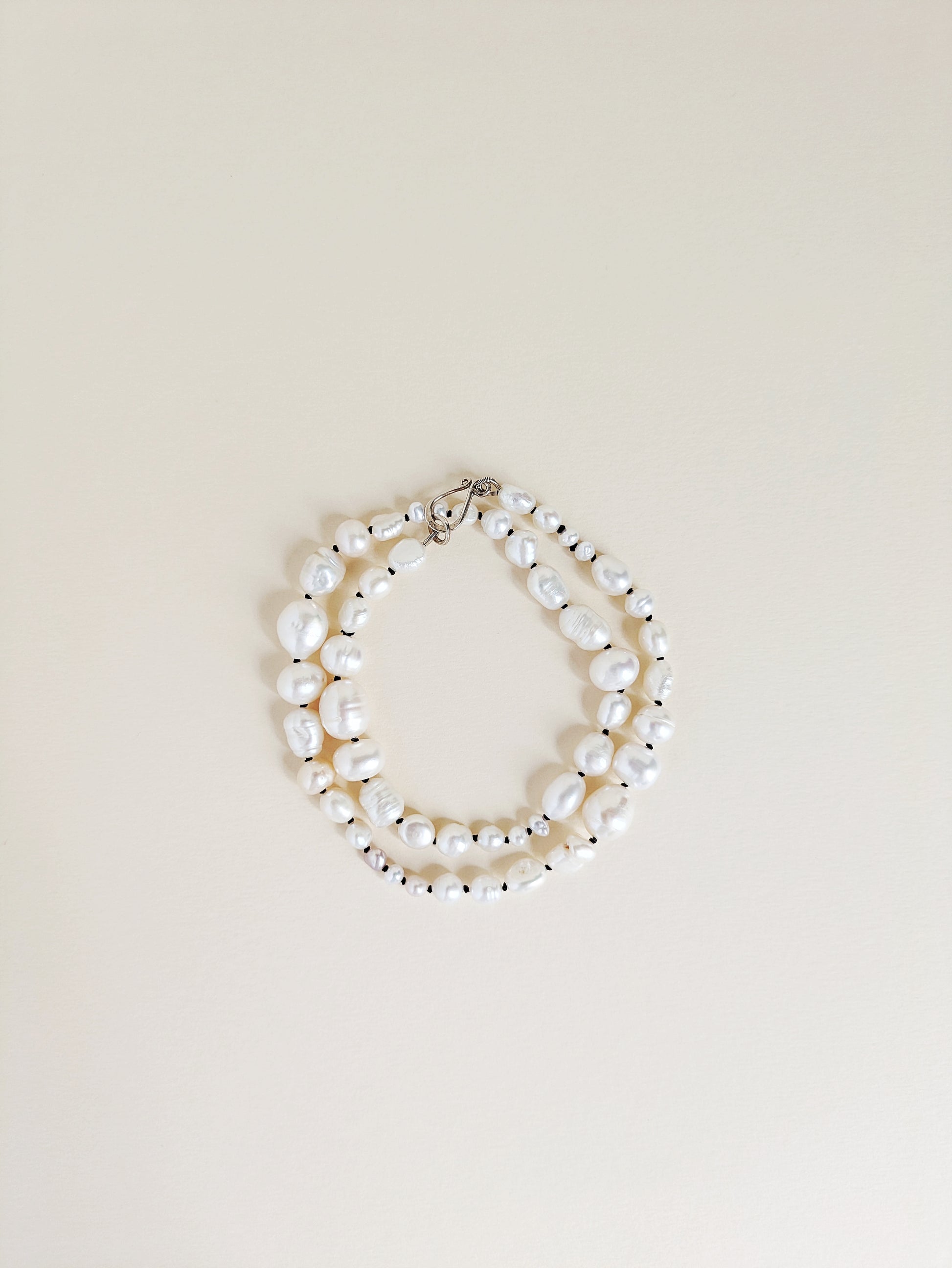 Pearl necklace or bracelet on a beige background