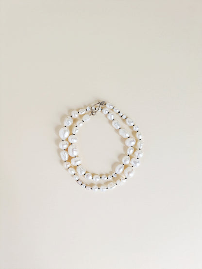 Pearl necklace or bracelet on a beige background