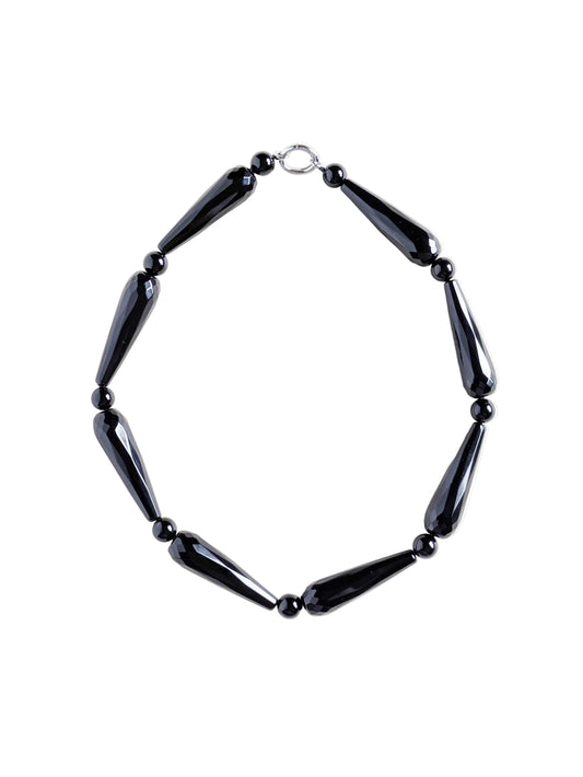 Onyx necklace Drama on a white surface.