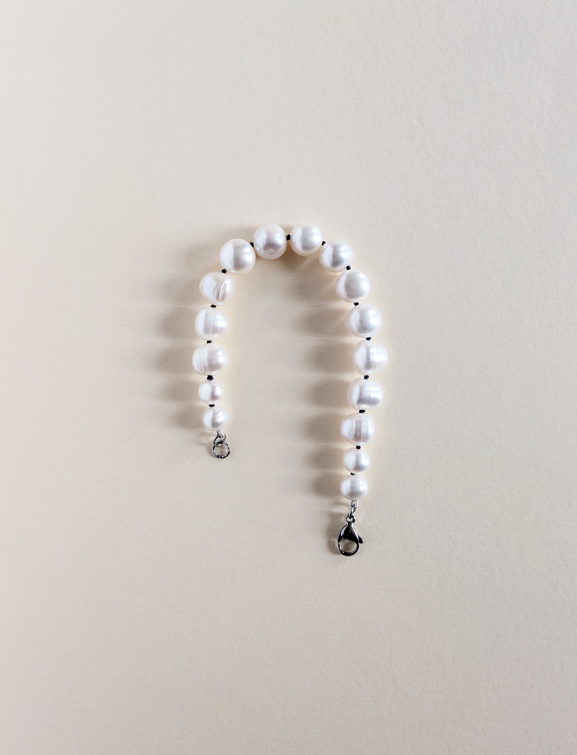 Pearl bracelet Chunky on a beige surface.