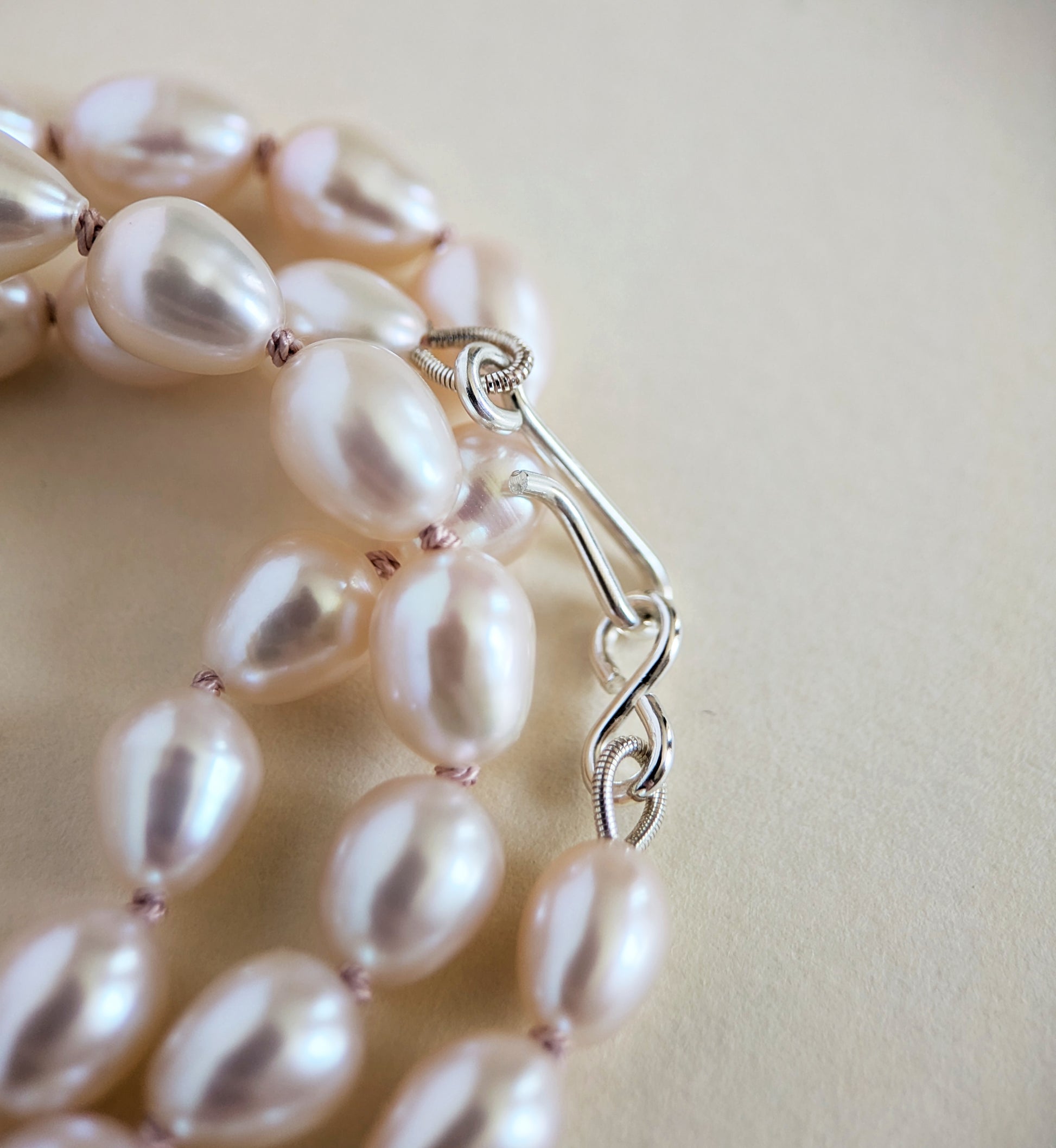 Silver clasp on a pearl necklace.
