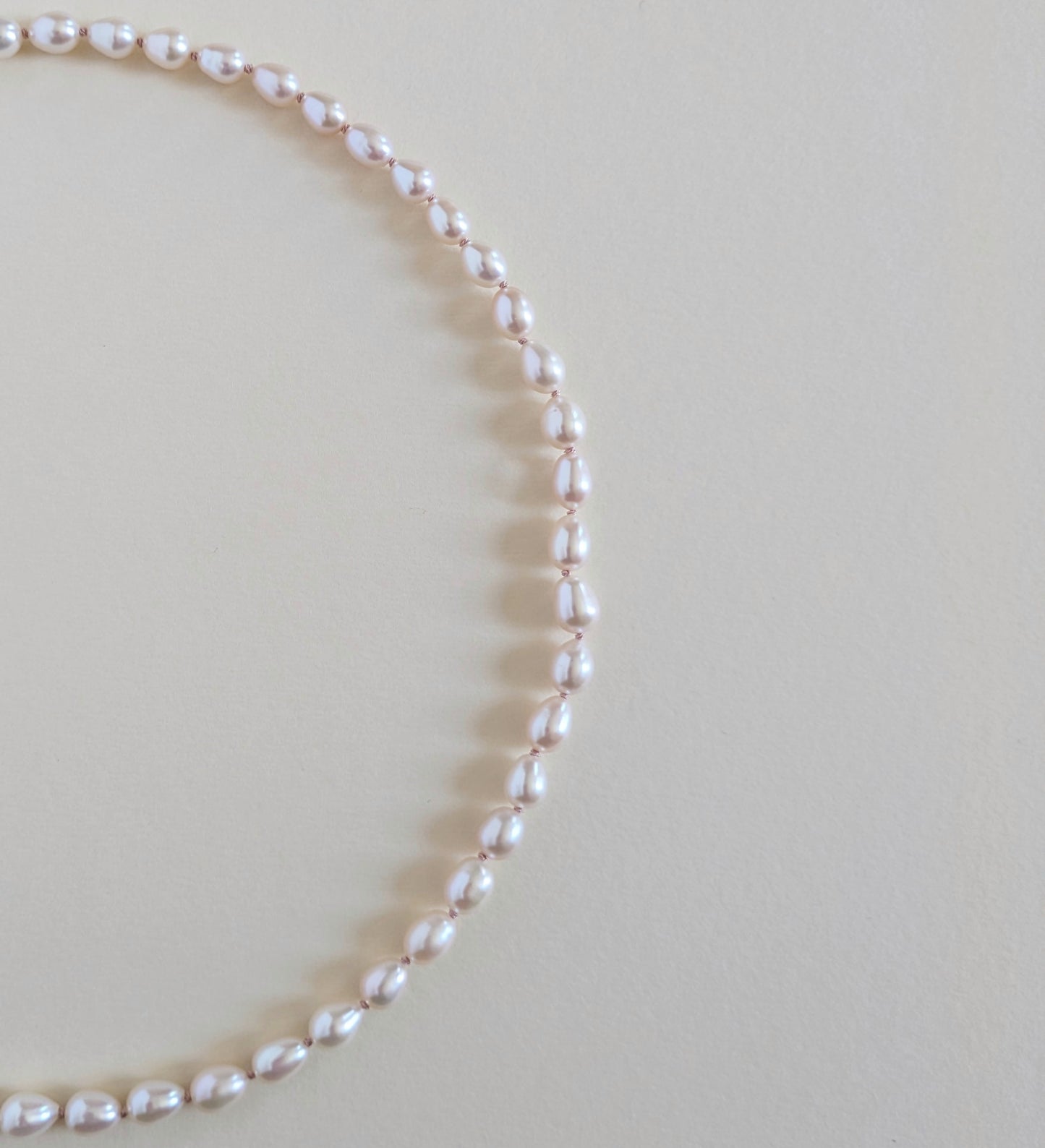 Pearl necklace on a light beige background