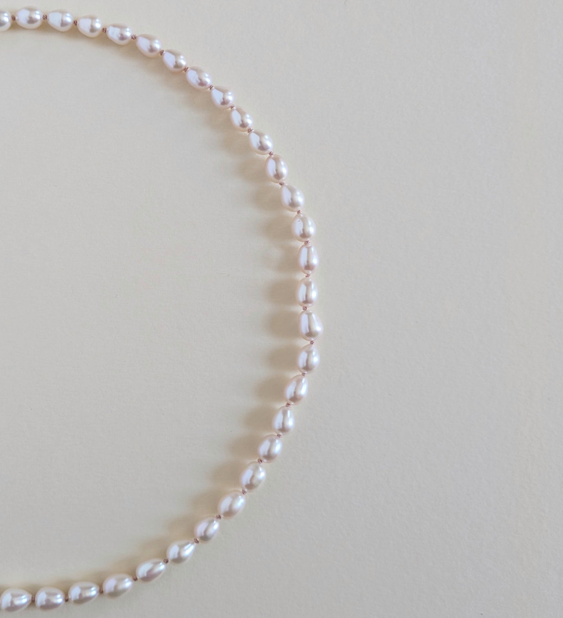 Pearl necklace on a light beige background