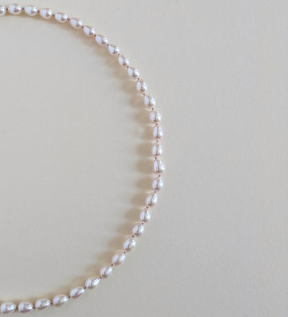 Pearl necklace on a light beige background