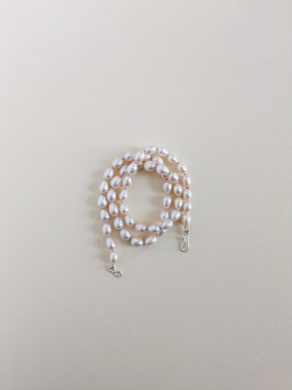Pearl necklace on a light beige background