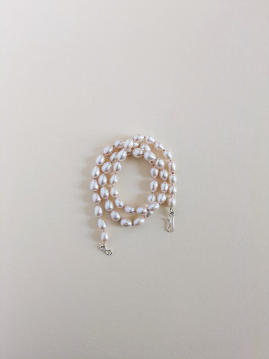 Pearl necklace on a light beige background