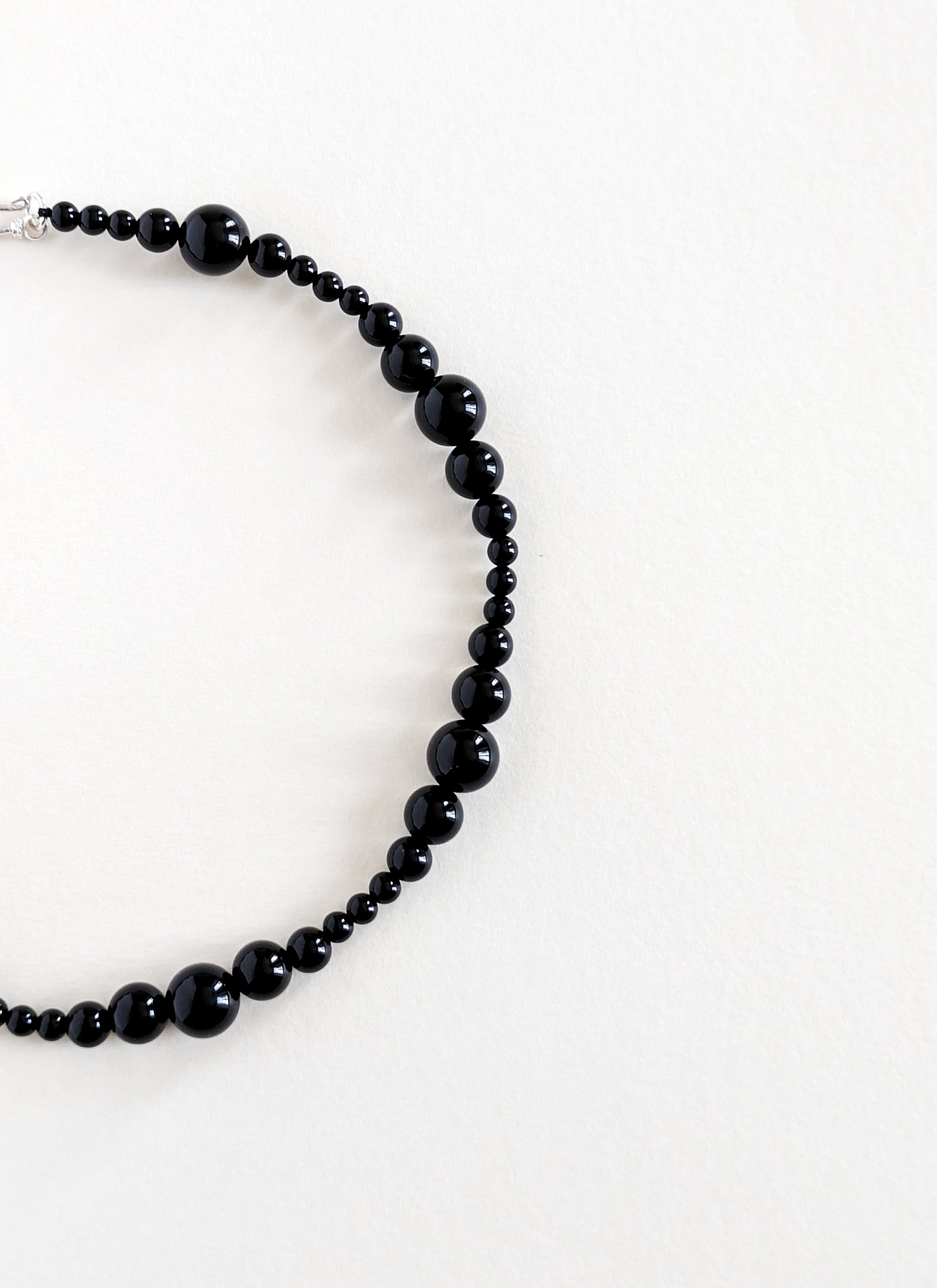 Black beaded necklace on a white background