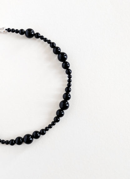 Black beaded necklace on a white background