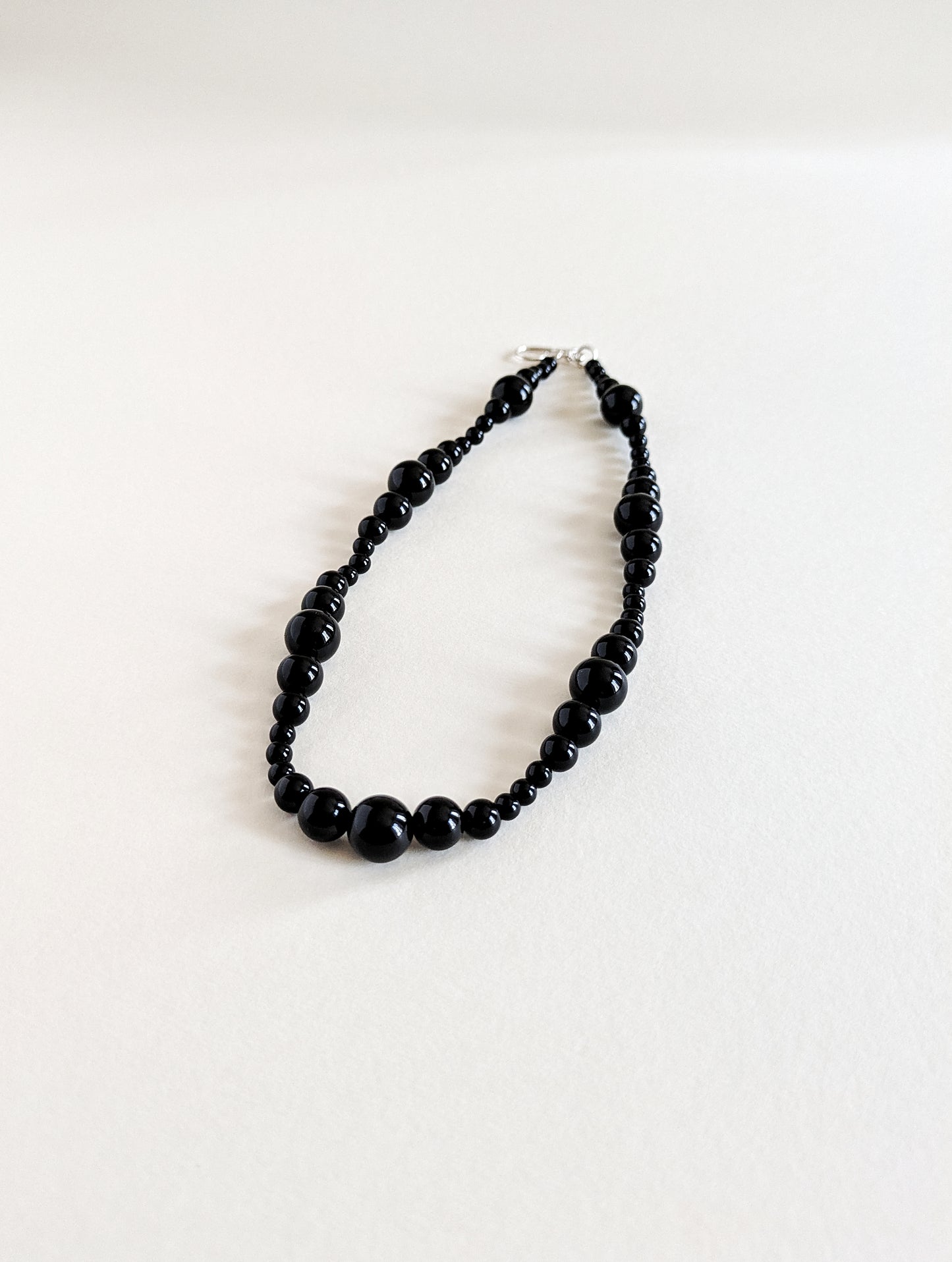 Black beaded necklace on a white background