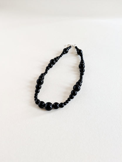 Black beaded necklace on a white background