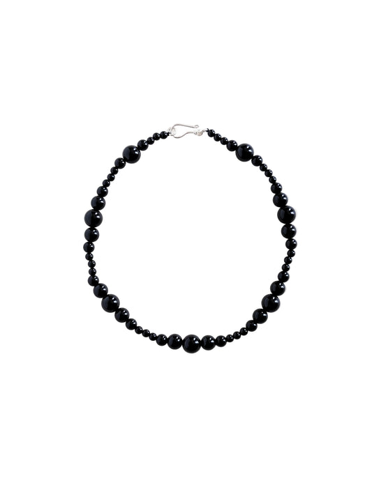Black beaded necklace on a white background
